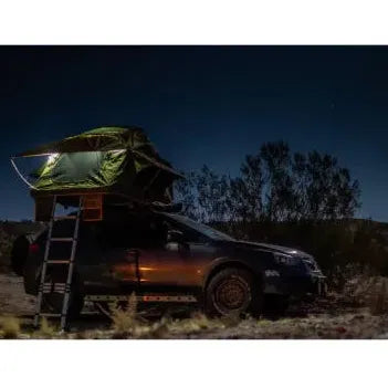 Car with a rooftop tent in a desert at night