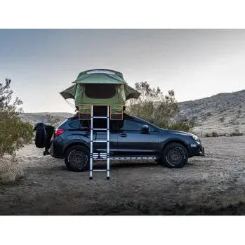 Roof top tent on a car in a desert setting with 'wildtrac' branding.